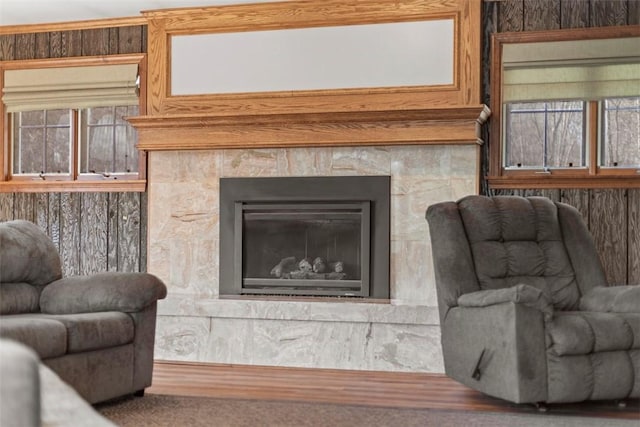 living room with wood finished floors and a tiled fireplace