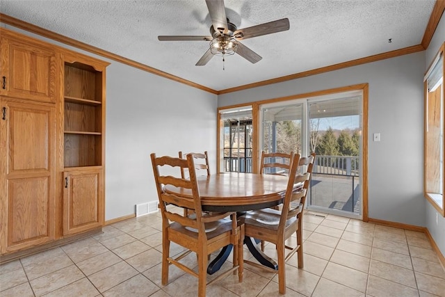 dining space with light tile patterned floors, visible vents, a textured ceiling, and crown molding