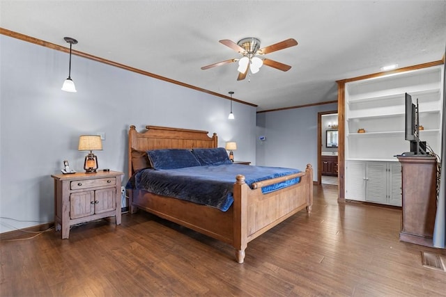 bedroom featuring a ceiling fan, wood finished floors, visible vents, baseboards, and crown molding