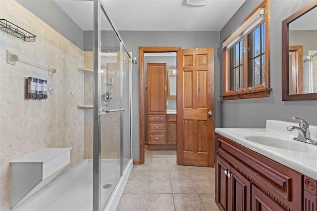 bathroom with tile patterned flooring, a shower stall, and vanity