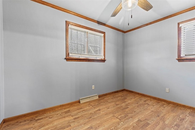 spare room featuring visible vents, crown molding, ceiling fan, baseboards, and light wood-type flooring