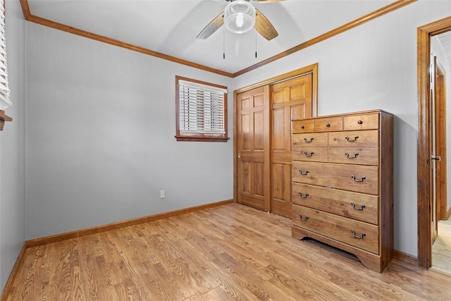 unfurnished bedroom with a closet, light wood-style flooring, crown molding, and baseboards