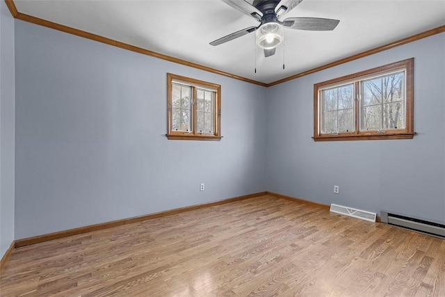 empty room featuring crown molding, plenty of natural light, wood finished floors, and visible vents