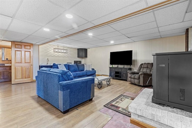 living area with recessed lighting, a paneled ceiling, and light wood-style floors