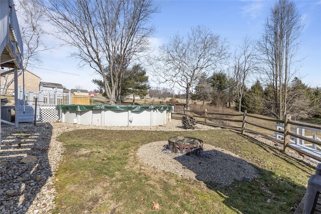 view of yard with a fenced in pool, fence, a deck, and an outdoor fire pit