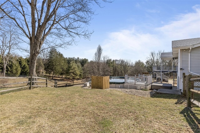 view of yard featuring a wooden deck and fence