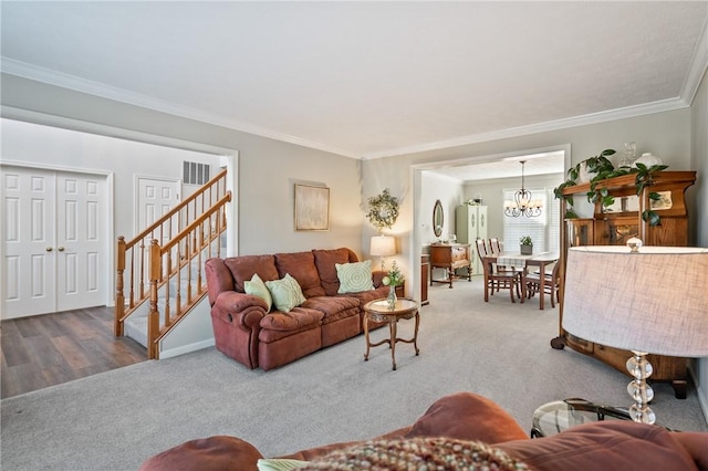 carpeted living room with a notable chandelier, stairs, and crown molding