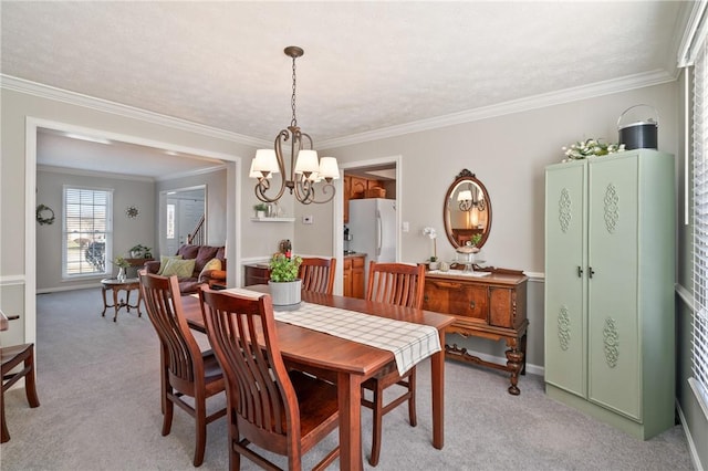 dining space with an inviting chandelier, light colored carpet, baseboards, and ornamental molding