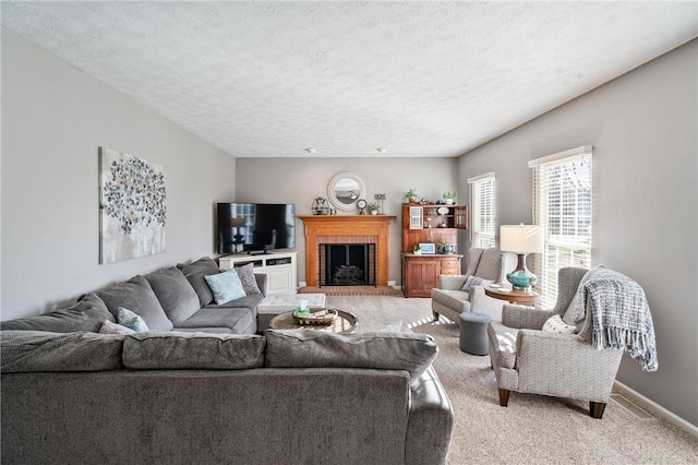 living room with light colored carpet, a brick fireplace, a textured ceiling, and baseboards