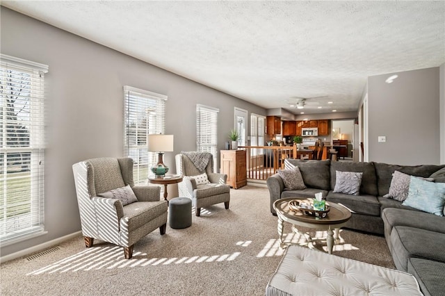 living area featuring visible vents, a healthy amount of sunlight, and a textured ceiling