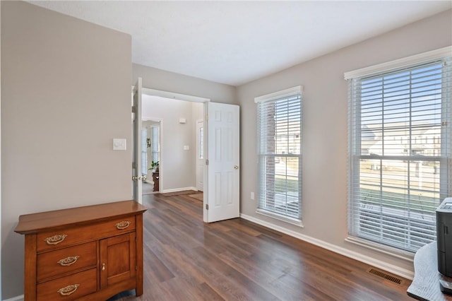 interior space with visible vents, baseboards, and dark wood-style flooring