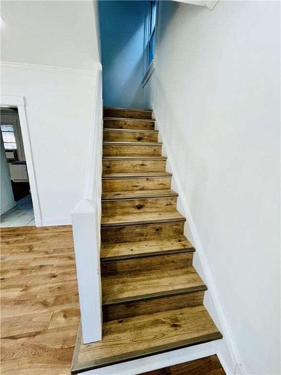 stairway with baseboards and wood finished floors