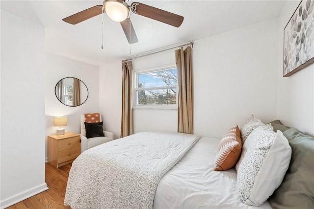 bedroom with light wood-type flooring, baseboards, and ceiling fan