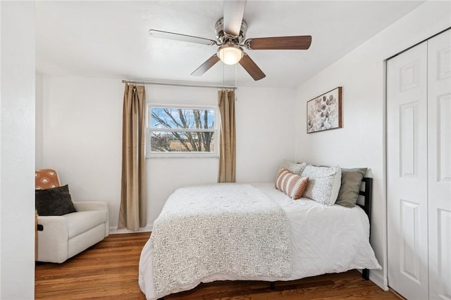 bedroom with a ceiling fan, wood finished floors, and a closet