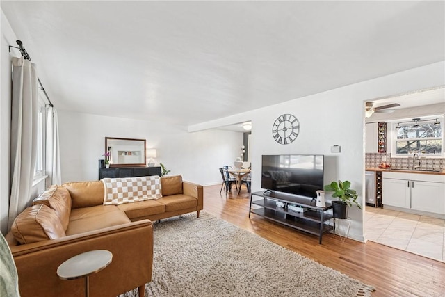 living room featuring light wood-style flooring and a ceiling fan