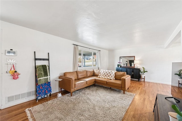 living room with visible vents, light wood-type flooring, and baseboards