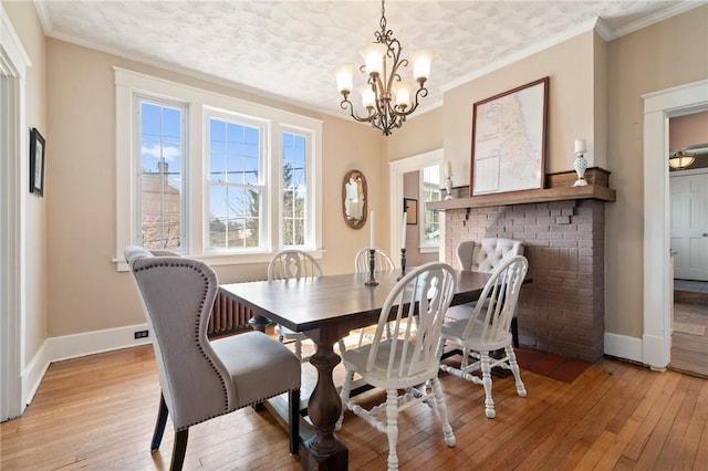 dining space with light wood finished floors, crown molding, and baseboards