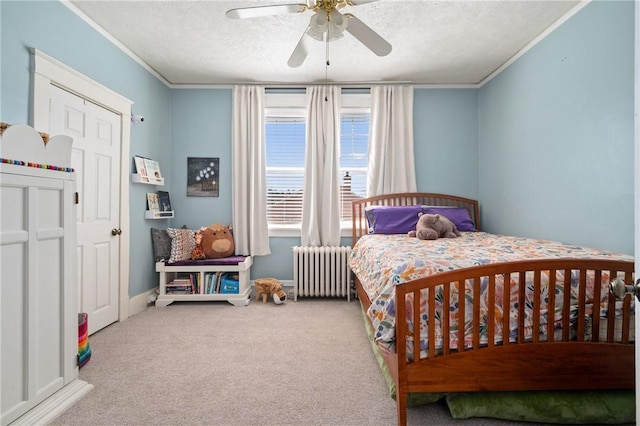 bedroom with a textured ceiling, radiator, carpet flooring, and crown molding