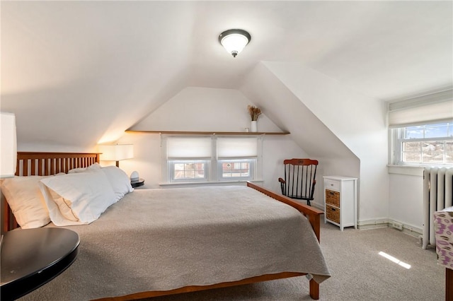 carpeted bedroom featuring lofted ceiling, radiator, and baseboards