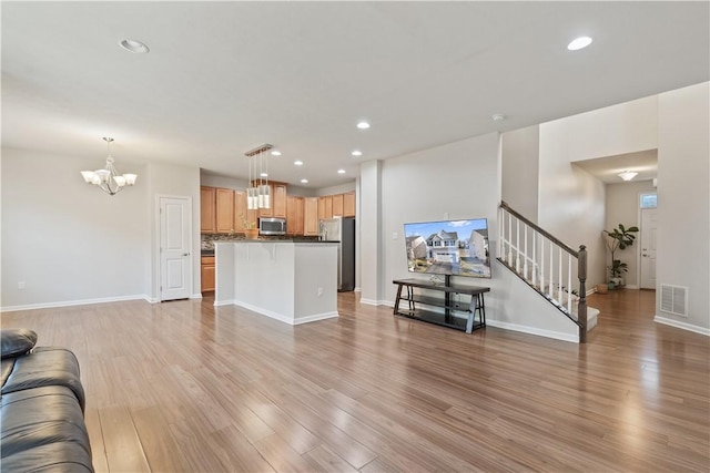 living room featuring stairs, recessed lighting, visible vents, and light wood-type flooring