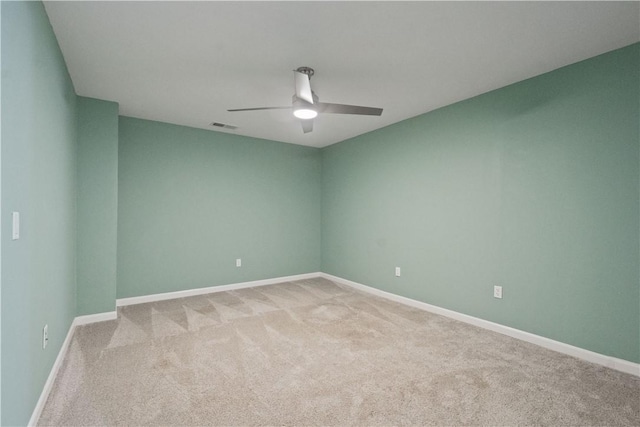 spare room featuring visible vents, light carpet, baseboards, and ceiling fan