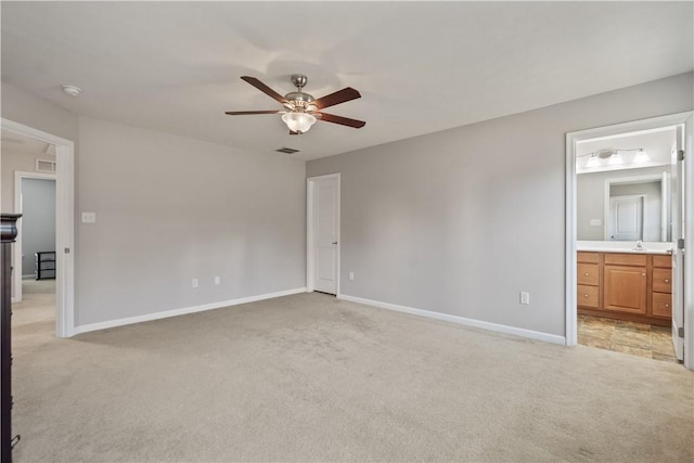 unfurnished bedroom featuring visible vents, light colored carpet, ensuite bath, and baseboards