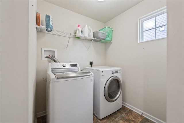 clothes washing area with laundry area, baseboards, and washing machine and clothes dryer