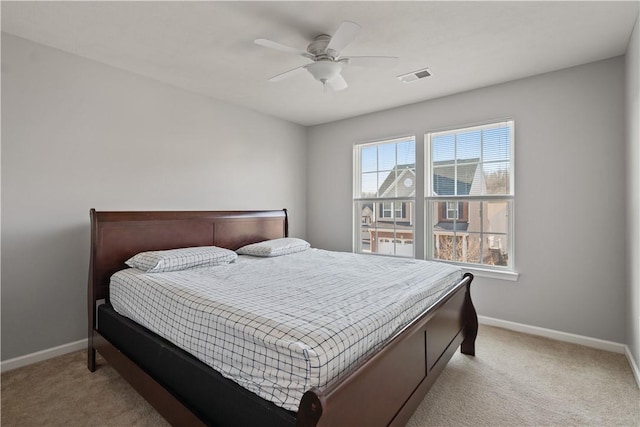 bedroom with visible vents, light carpet, baseboards, and a ceiling fan