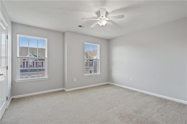 empty room featuring visible vents, carpet floors, and plenty of natural light