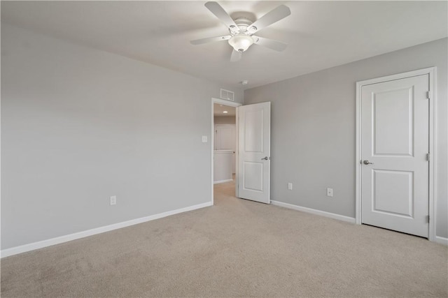 unfurnished bedroom featuring visible vents, light colored carpet, baseboards, and ceiling fan