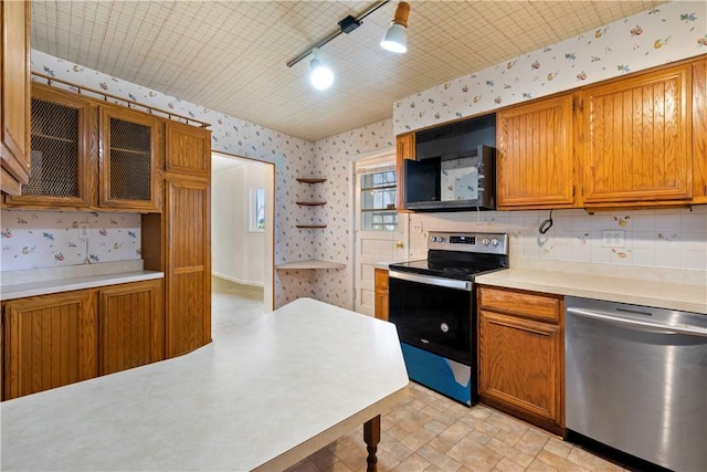 kitchen featuring wallpapered walls, light countertops, appliances with stainless steel finishes, brown cabinetry, and open shelves