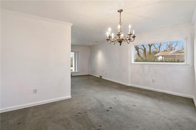 carpeted empty room with baseboards, plenty of natural light, a notable chandelier, and crown molding