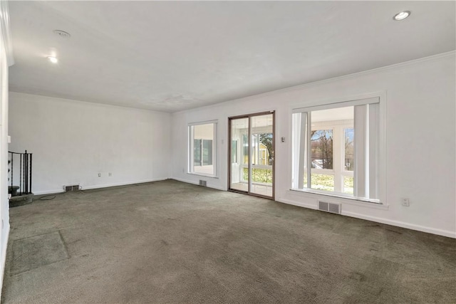 spare room featuring crown molding, carpet, visible vents, and baseboards