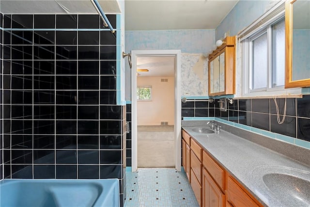 bathroom featuring wallpapered walls, double vanity, shower / bathing tub combination, and a sink