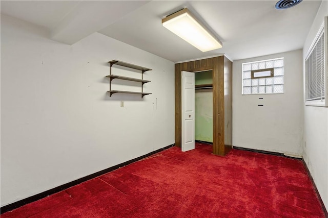 unfurnished bedroom featuring dark colored carpet and baseboards