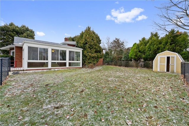 view of yard with a storage unit, an outbuilding, a fenced backyard, and a sunroom