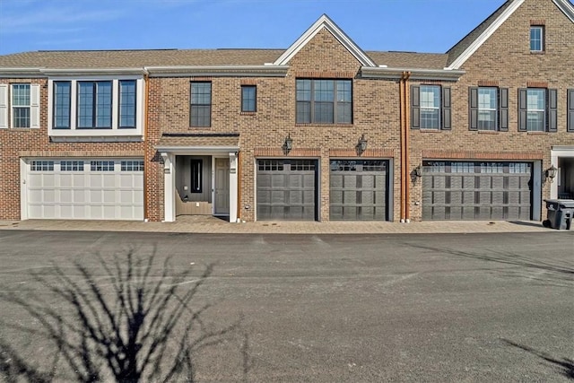 multi unit property featuring brick siding and an attached garage