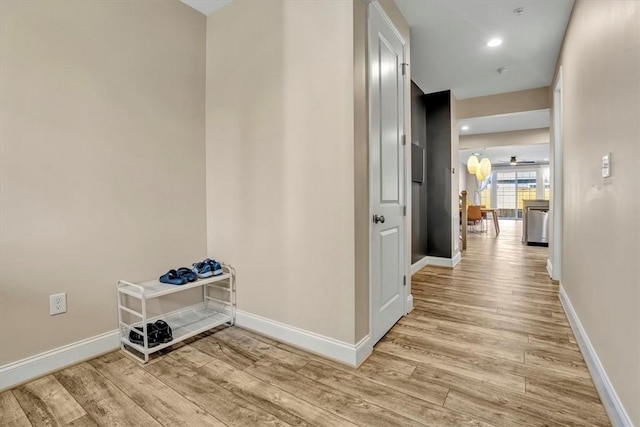 corridor featuring recessed lighting, baseboards, and light wood finished floors