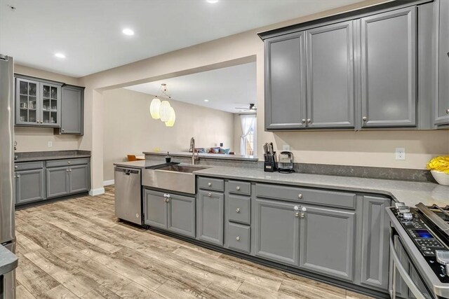 kitchen featuring recessed lighting, a sink, gray cabinetry, appliances with stainless steel finishes, and light wood-type flooring