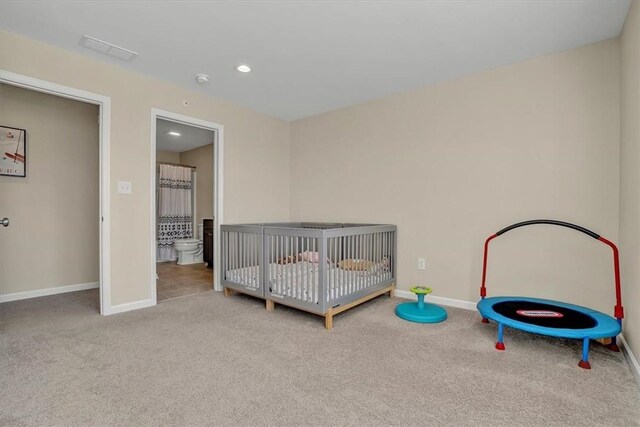 bedroom featuring recessed lighting, baseboards, a crib, and carpet flooring