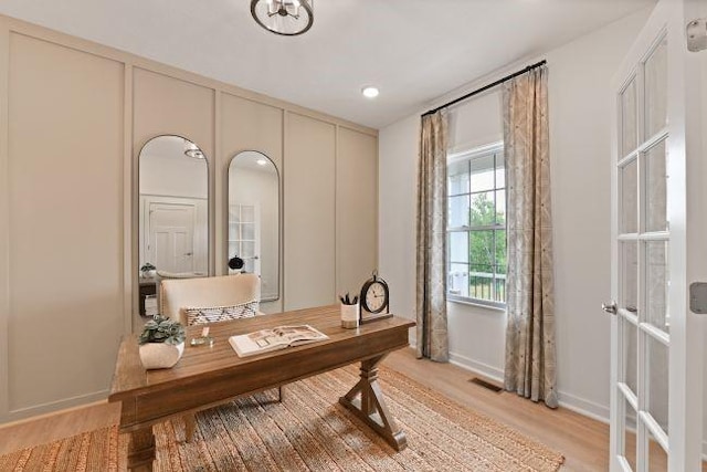 office area featuring visible vents, baseboards, and light wood-style floors