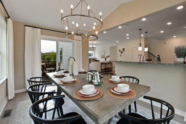 dining room featuring visible vents, lofted ceiling, recessed lighting, light wood-style floors, and a notable chandelier