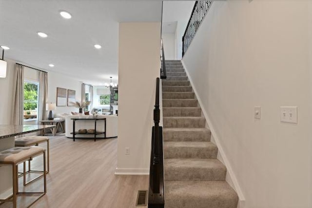 stairway with visible vents, baseboards, a chandelier, recessed lighting, and wood finished floors