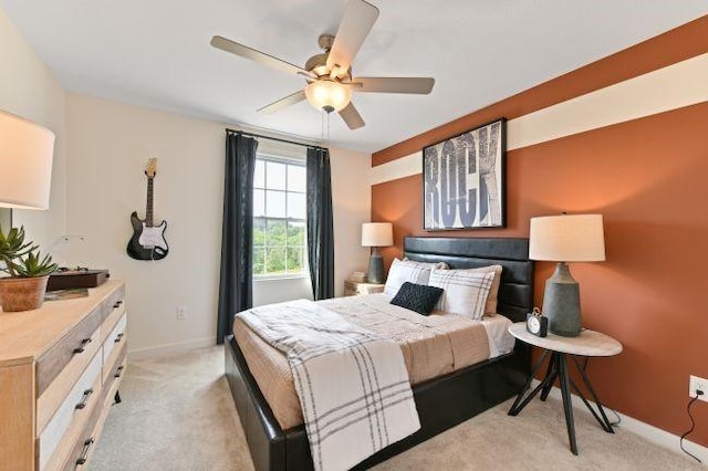 bedroom with light colored carpet, a ceiling fan, and baseboards