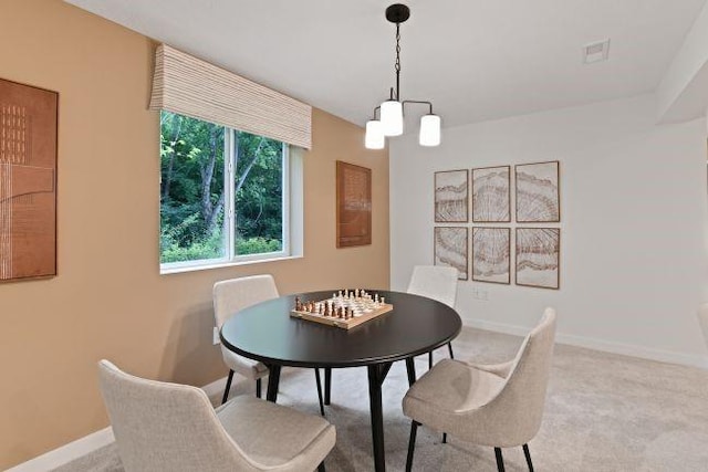 dining area with baseboards, a notable chandelier, and carpet floors