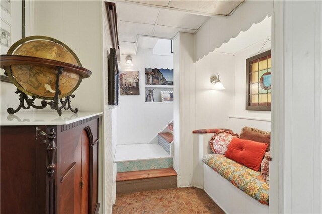 interior space featuring a paneled ceiling and stairs