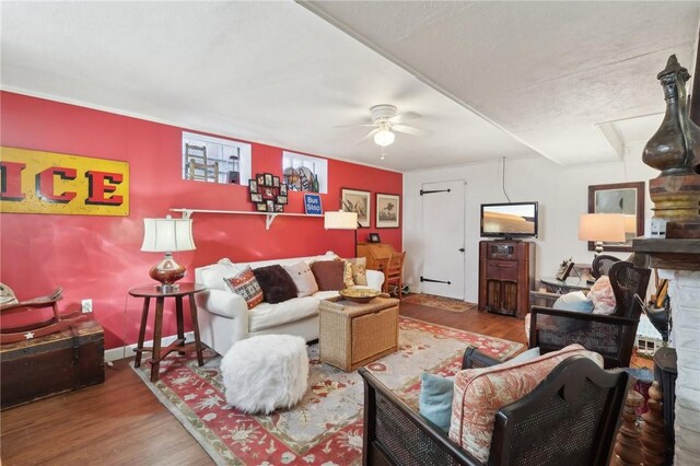 living room featuring baseboards, wood finished floors, and a ceiling fan