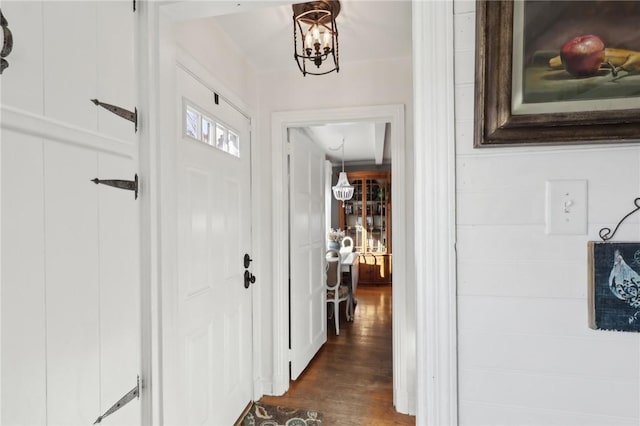 foyer entrance featuring dark wood finished floors and a chandelier