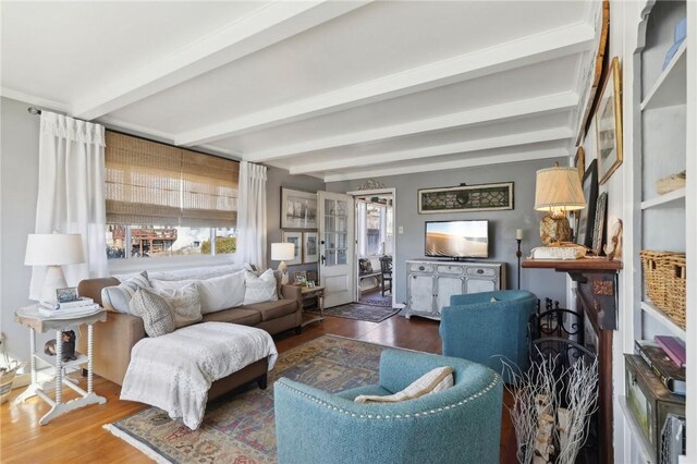 living room with beamed ceiling and wood finished floors