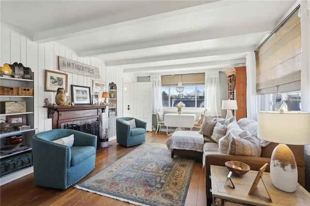 living area featuring a wealth of natural light, beam ceiling, a fireplace, and wood finished floors